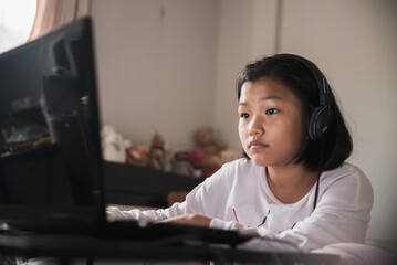 Asian children using laptop to learning and doing homework at home. Happy Thai Students study online for study to the exam. Education concept.