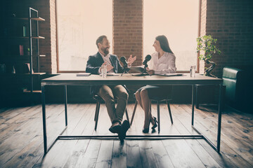 Full length photo of two business people corporate partners answer journalist press conference...