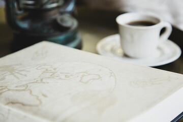 Still life with a cup of coffee and an open book. Retro style.