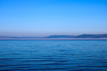 Obraz premium Misty Sea View of Island in West Scotland on a Summer Morning