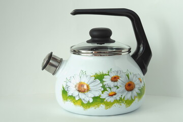 The kettle is an enamelled classic with a whistle. White