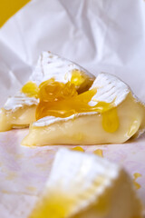  camembert cheese with honey on white paper