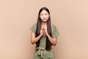 asian young woman scheming and conspiring, thinking devious tricks and cheats, cunning and betraying
