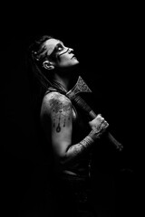 Obraz premium Portrait of a young tattooed Viking warrior with an ax on her shoulder