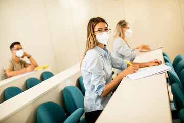 Female student wearing face protective medical mask for virus protection at lecture hall