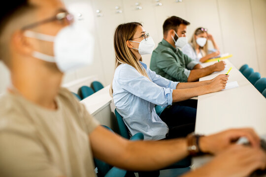 Female student wearing face protective medical mask for virus protection at lecture hall