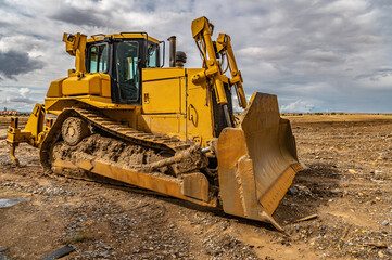 Obraz na płótnie Canvas Excavator working on a muddy construction site
