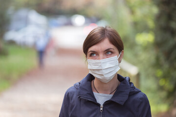 Flue and corona safety concept. Woman wearing face mask to protect herself, outdoors