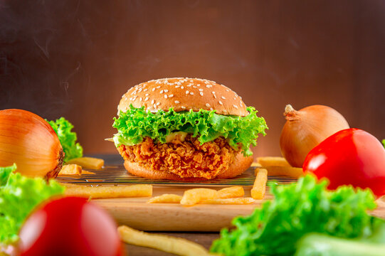 Hemberger Fried chicken. Delicious hamburgers, delicious fast food or junk food.  A large hamburger served on wood plate. Junk food yummy Meat hamburger on wooden table.