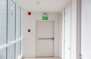 Green emergency exit sign showing the way to escape. Fire exit in the building.