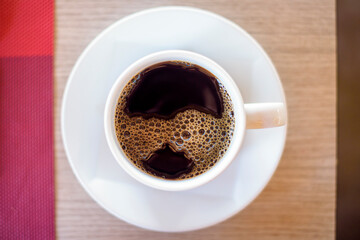 top view of cup of hot black coffee  on wooden table background