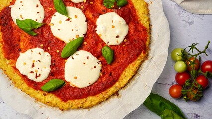 Homemade Cauliflower Crust pizza topped with fresh basil leaves
