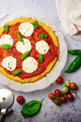 Homemade Cauliflower Crust pizza topped with fresh basil leaves