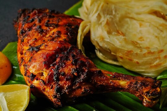 Kerala Parotta or Porotta with grilled chicken, selective focus