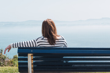 woman from behind sitting on a bench