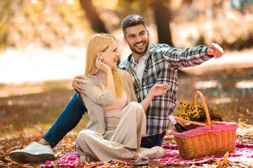 Happy couple picnic in the park during autumn fall season