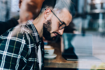 Stylish man in eyeglasses sitting in cafe
