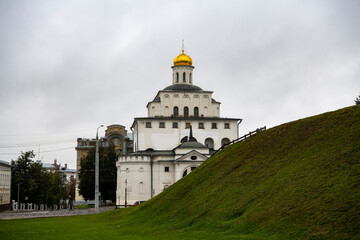 ancient stone gate in the form of a fortress tower against a gray sky