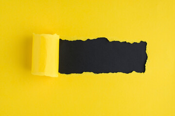 Top above overhead view photo of torn bright yellow paper over black background with copyspace