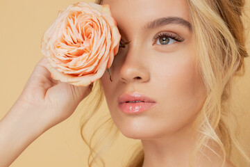 Portrait young beautiful woman with pink flowers on eyes. Spring fashion photo and skin eyelash care