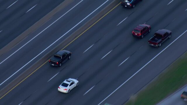 High angle aerial, black truck drives down Houston freeway