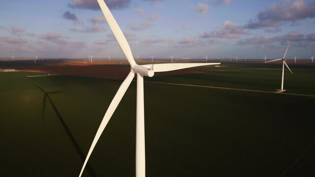 Wide aerial, windmills in Texas cotton fields at sunset