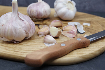 Organic garlic. Fresh garlic cloves and garlic bulb on a wooden cutting board. Garlic for healthy eating. Concept of spices for healthy cooking. Closeup