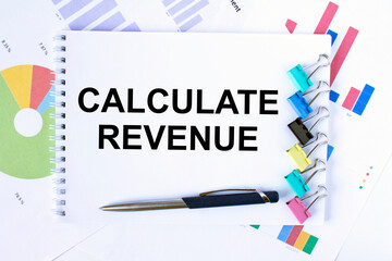 Notepad with text Calculate Revenue, paper clips, blue pen on financial diagrams