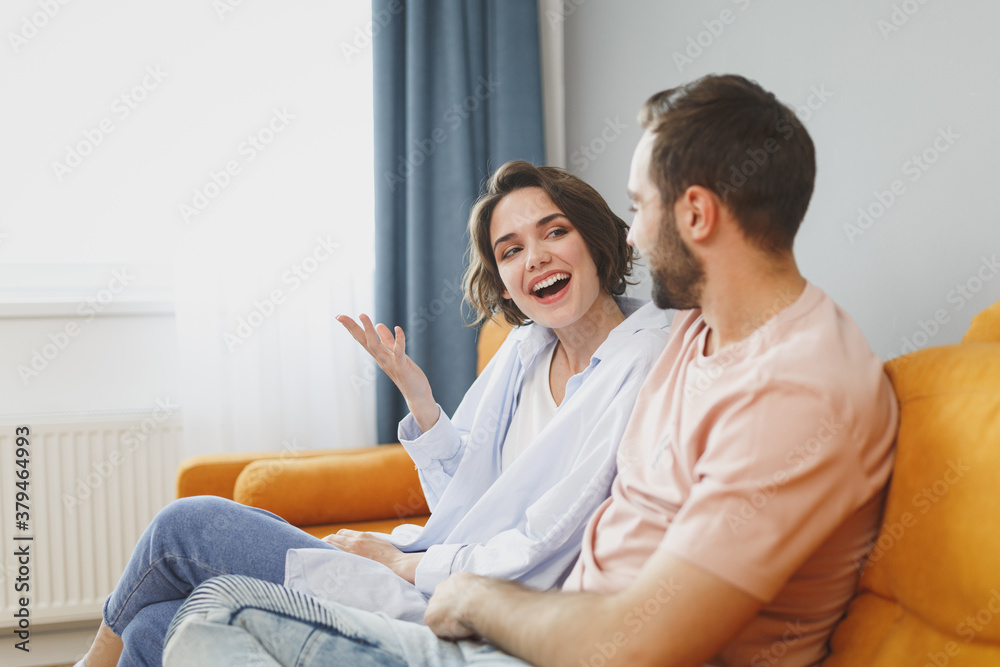 Canvas Prints excited cheerful funny young couple two friends man woman 20s in casual clothes sitting on couch hug