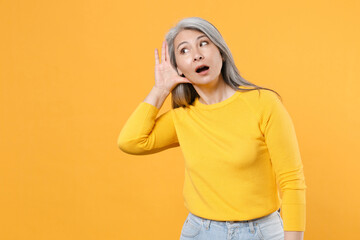 Shocked amazed curious gray-haired asian woman wearing casual clothes standing try to hear you...