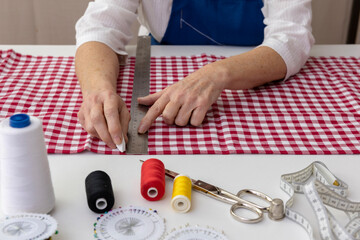 Costurera marca la tela con tiza blanca antes de cortar