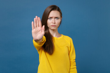 Displeased dissatisfied young brunette woman 20s wearing yellow casual clothes posing standing...