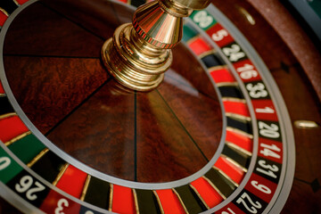 Casino, gambling and entertainment concept - roulette table and stack of poker chips