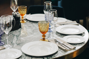 tableware Glasses, flower fork, knife served for dinner in restaurant with cozy interior