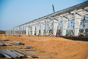 Steel frame workshop is under construction against a blue sky