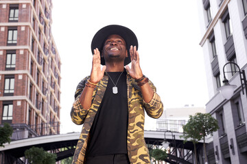 positive african american celebrity went outside for a walk with the fans, wearing fashionable...