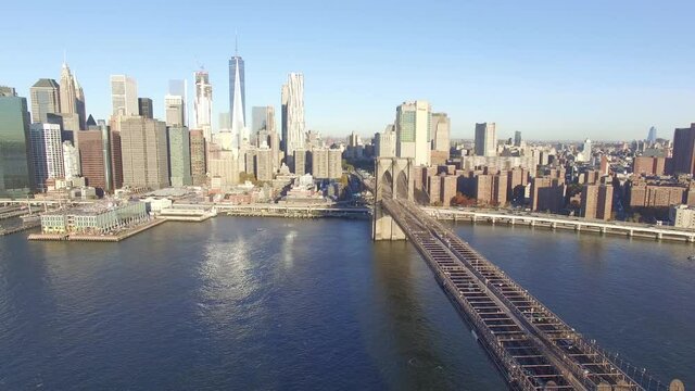 Vista a&eacute;rea del skyline de Manhattan al amanecer, el drone volando hacia atr&aacute;s sobre el Puente de Brooklyn y curanzo el R&iacute;o Este