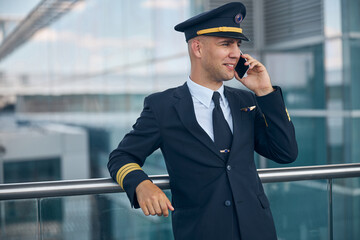 Cheerful male pilot talking on cellphone at airport © Svitlana