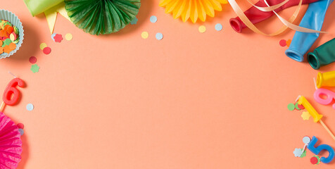 Birthday party background of living coral color. Party accessories on orange