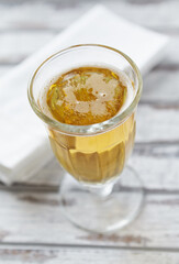 Glass of beer on bright wooden background.