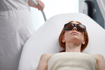 doctor cosmetologist applying apparatus on client skin during a procedure of microcurrent therapy, in a beauty salon. cosmetology and professional skin care