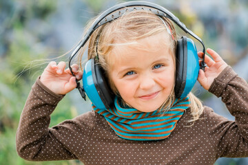 Happy toddler girl wearing earmuffs