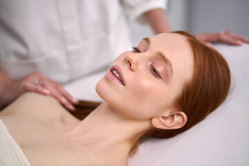 young redhead woman going to get face lifting procedures in salon, lie on bed waiting for cosmetologist, enjoy, calm