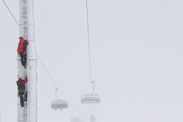 Heroes rescue teams on a chairlift at ski resort on the Dolomites. Emergency rescue passengers with...