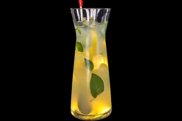 Fresh lemonade with Elderflower syrup in a bottle with lemon and ice with reflection,
