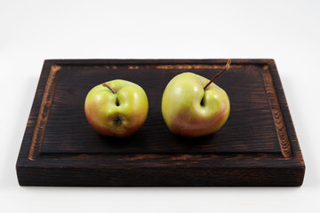 Ugly fruits. Two green apples with flaws on a dark wooden cutting board.  Selective focus, copy space. Concept - Food waste reduction. Using in cooking imperfect products