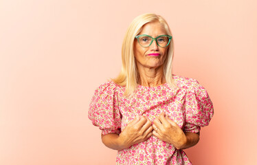 middle age woman feeling terrified, backing off and screaming in horror and panic, reacting to a...