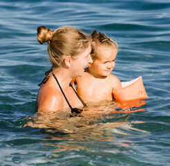 Mother with toddler girl in sea