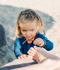 Girl playing with foot on beach
