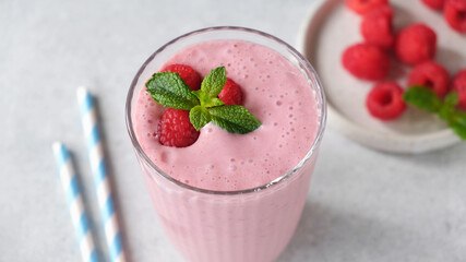 Glass of raspberry smoothie on concrete table background, closeup view